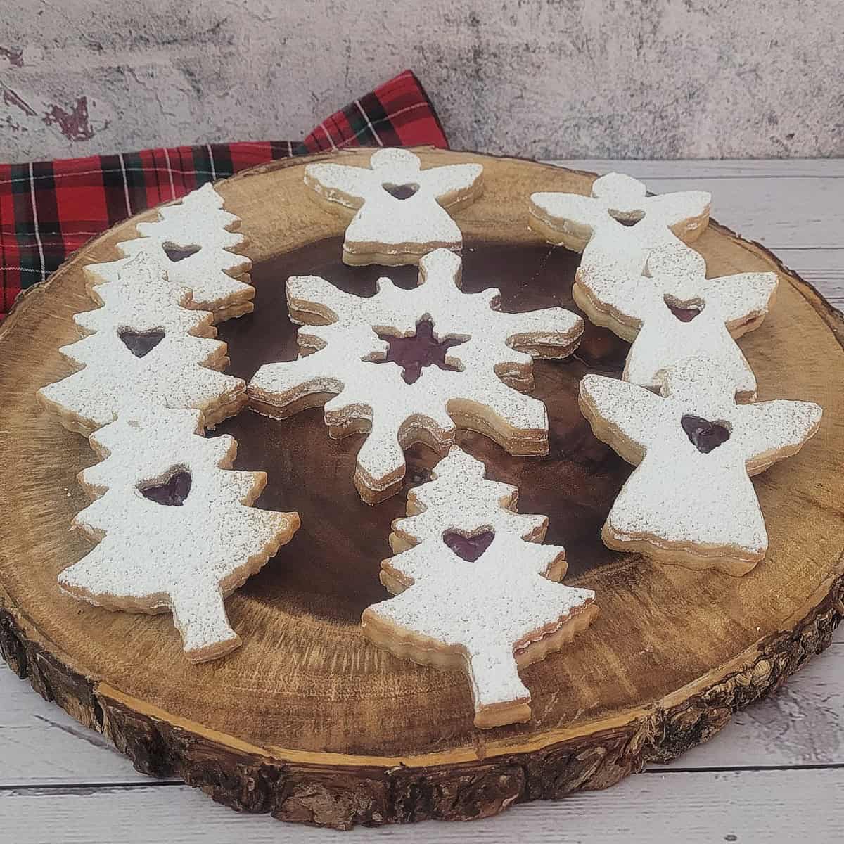 Holiday Linzer cookies on a wooden serving platter