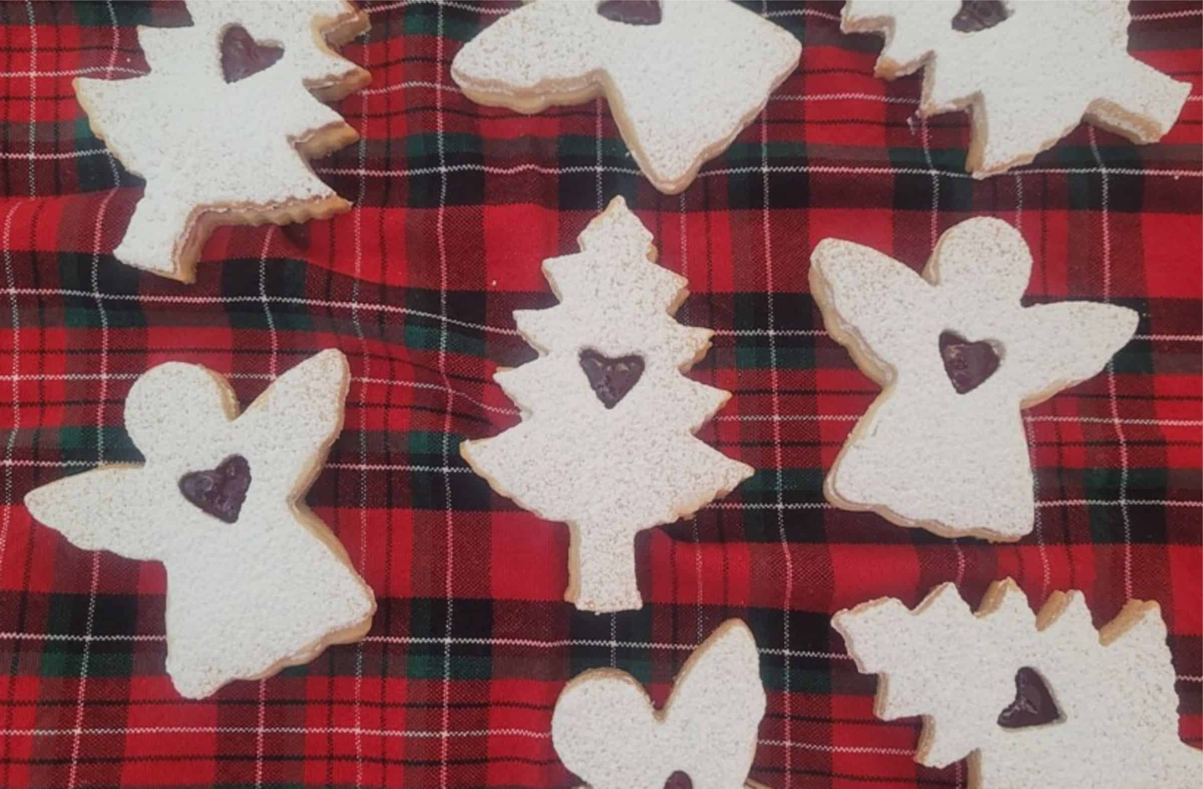 Linzer cookies filled with raspberry preserves on a holiday napkin