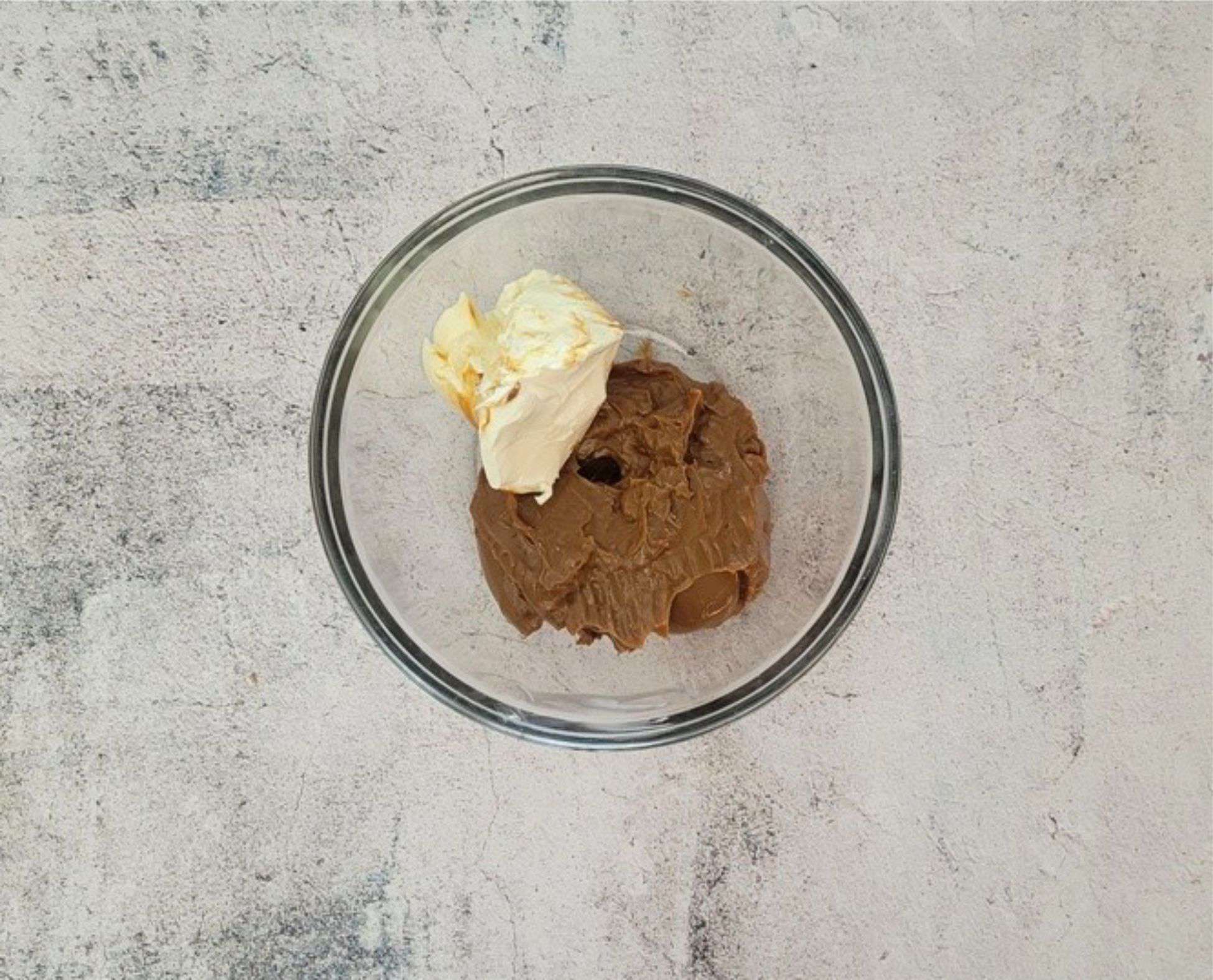 room temperature cream cheese and dulce de leche in a glass bowl