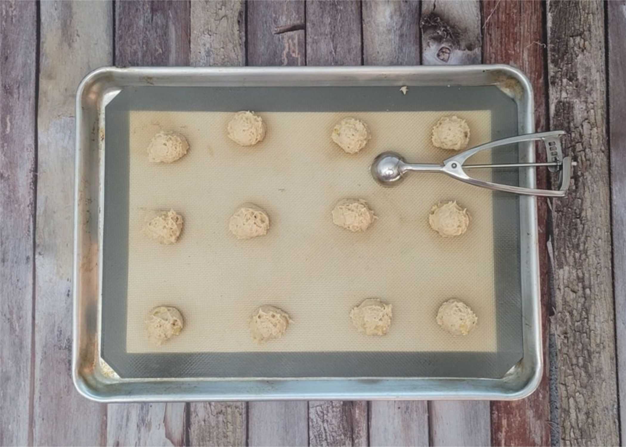 cookie dough scooped in balls on a sheet pan prior to baking