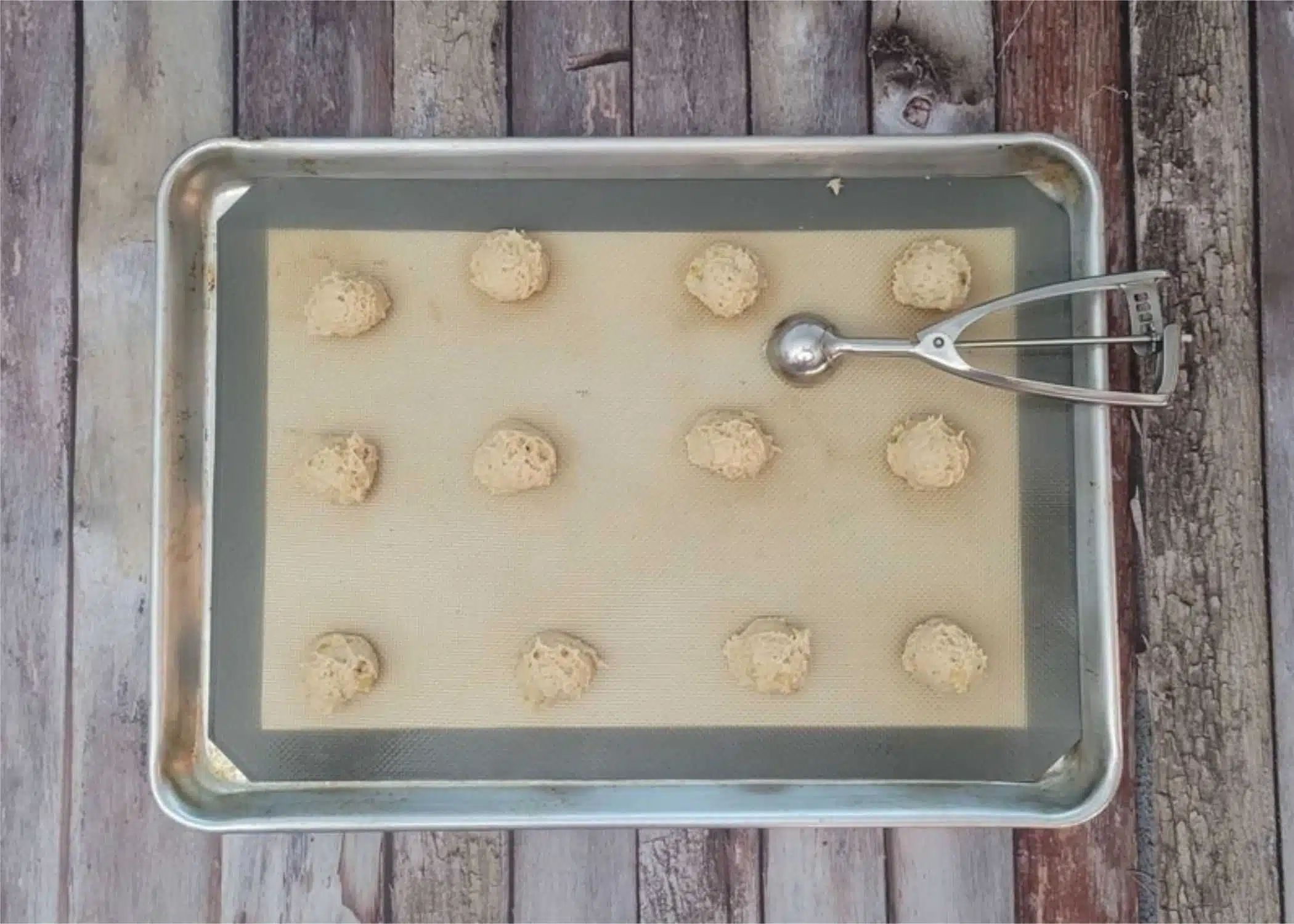 cookie dough scooped in balls on a sheet pan prior to baking