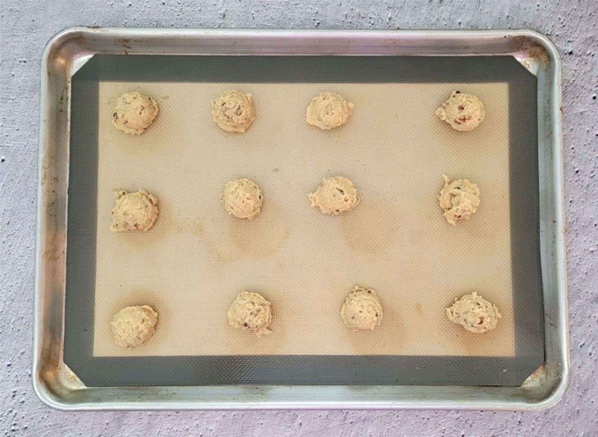 12 pecan praline cookies scooped onto a baking sheet pan