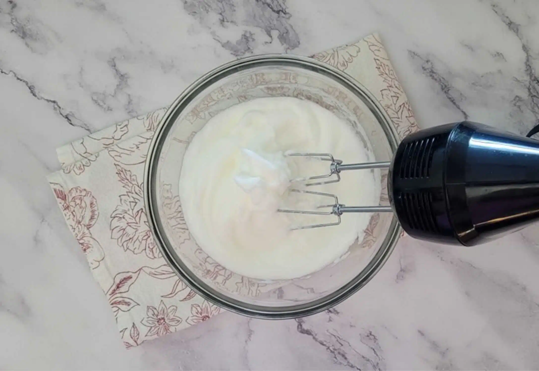 egg whites in a bowl mixed to medium peaks with a hand mixer