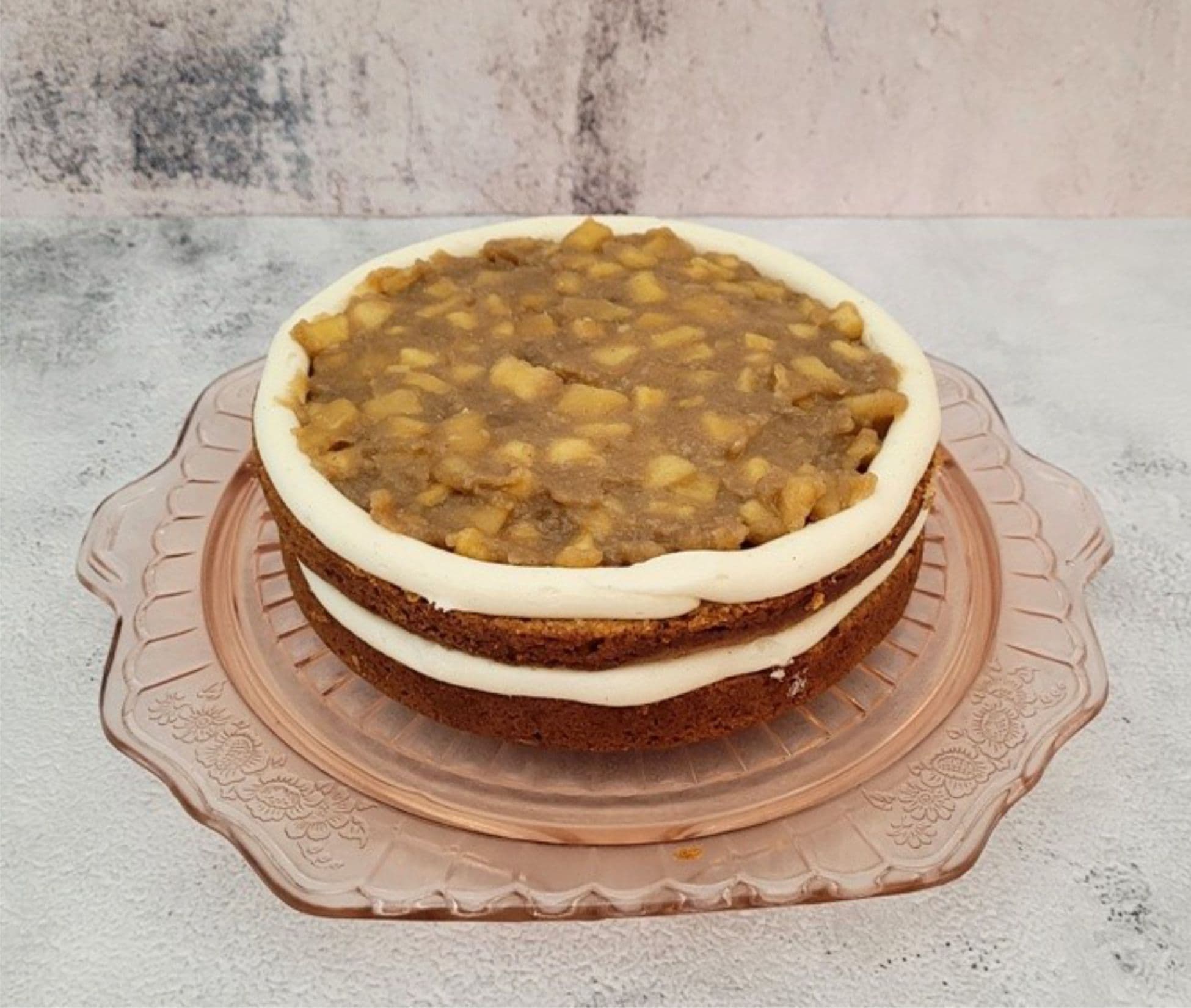 assembling cake by adding apple filling between layers