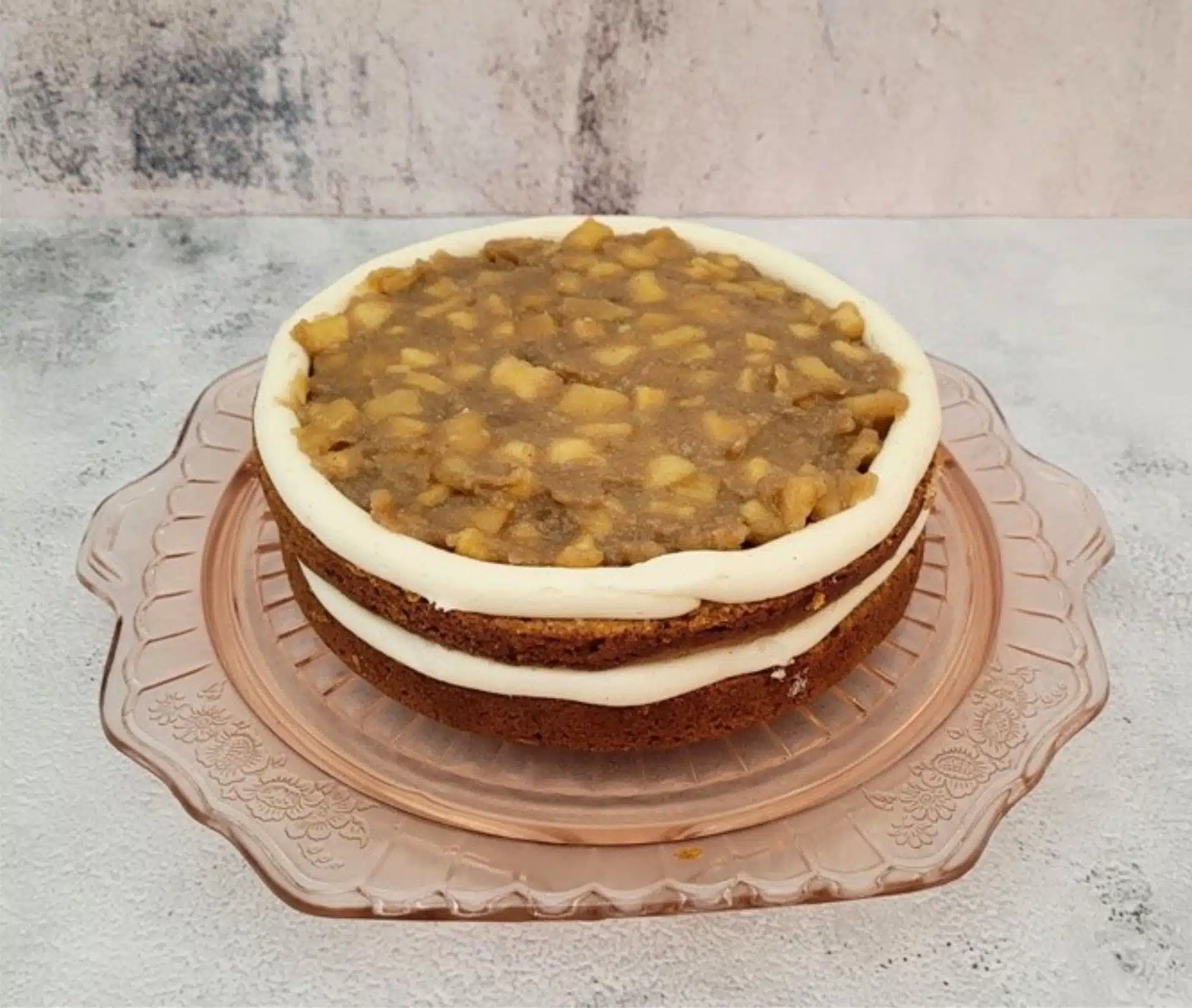 assembling cake by adding apple filling between layers