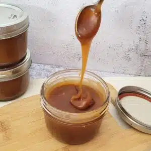 jar of caramel sauce with caramel dripping back into jar