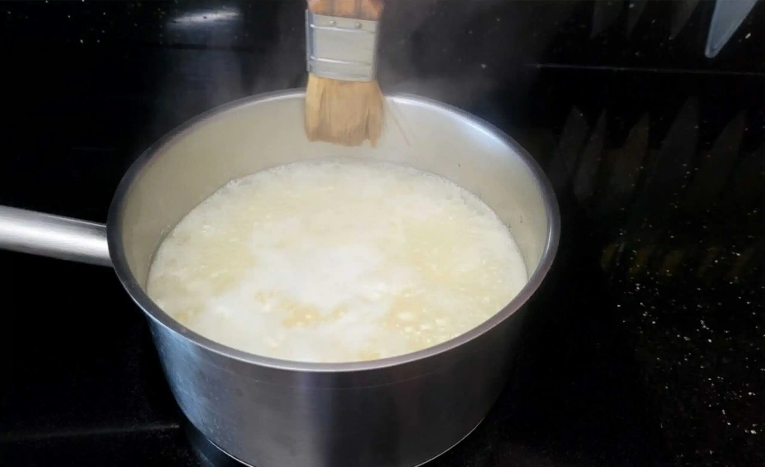 wiping down sugar crystals on side of saucepan while making pistachio brittle