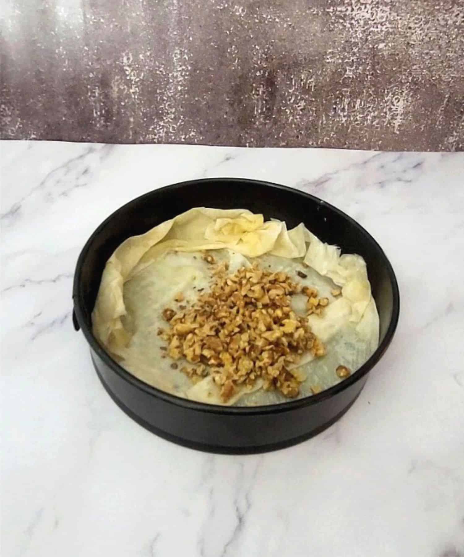 walnut and honey mixture poured into baking pan over layer of phyllo