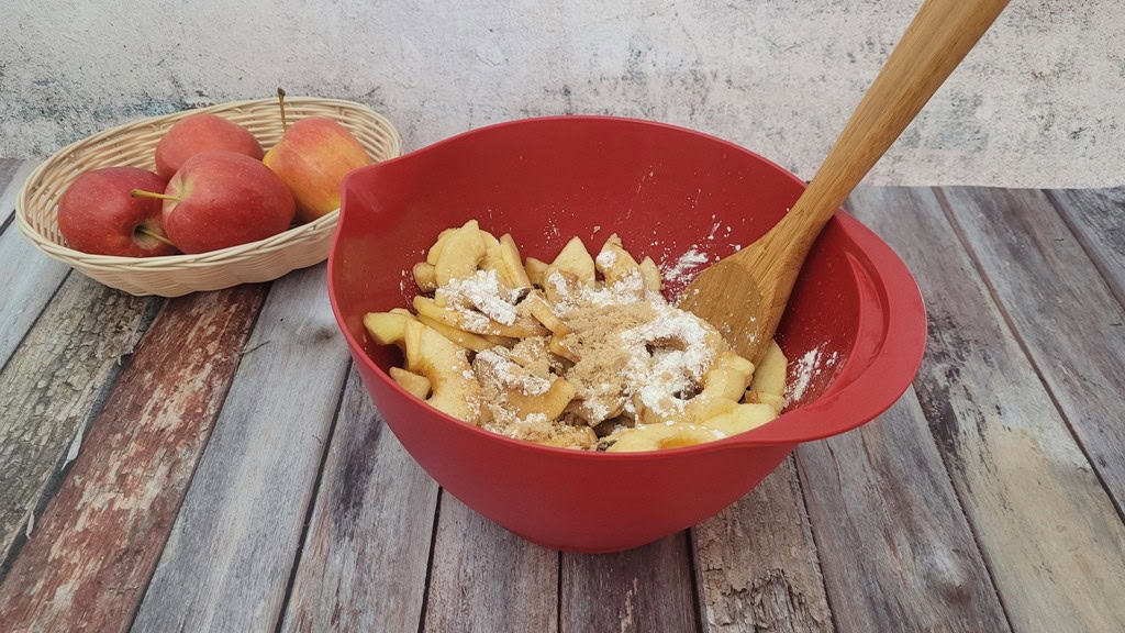 macerated apples and raisins in a bowl with cornstarch, sugar and spices added