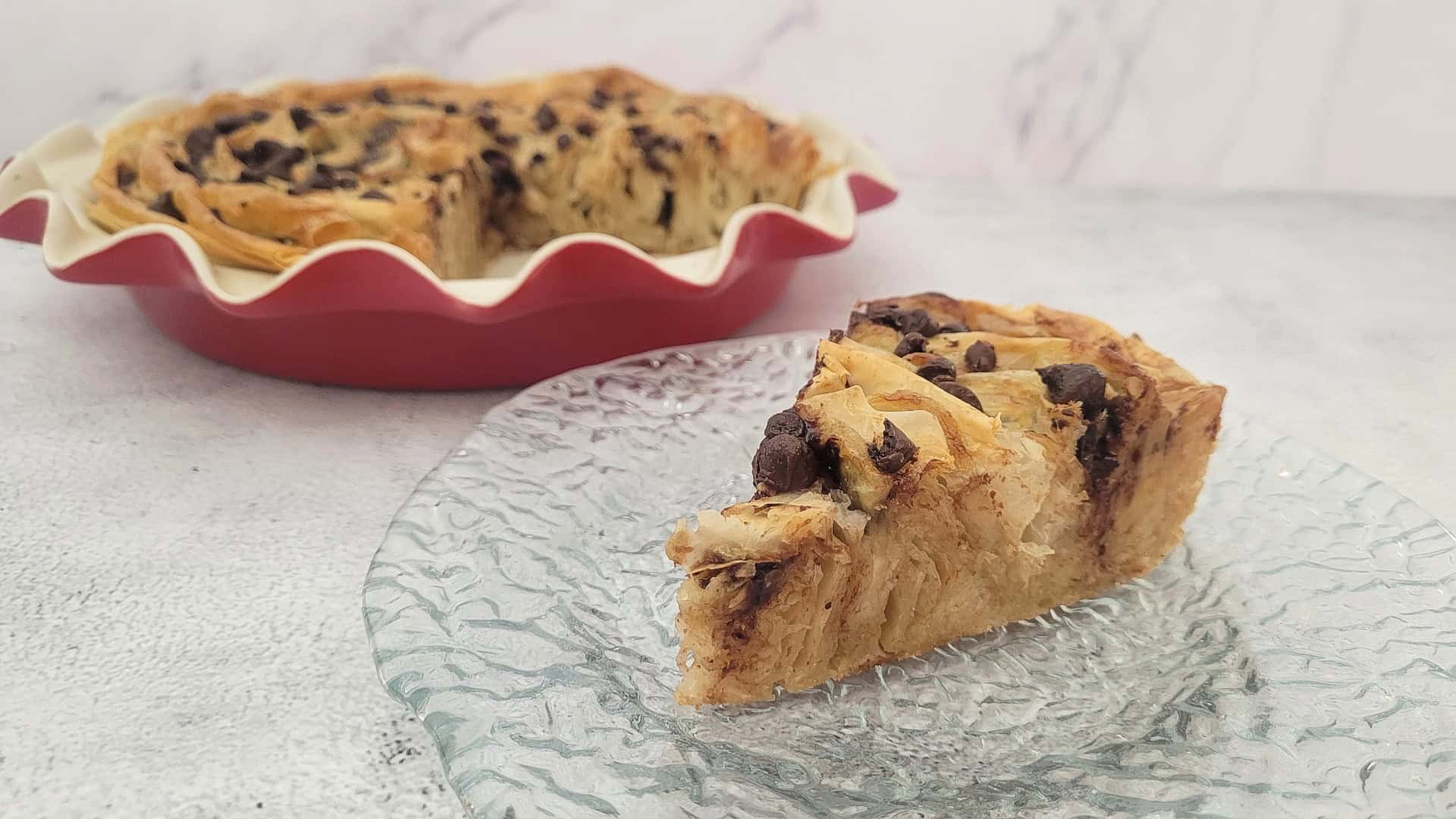 banana chocolate crinkle pie slice on a plate and pie pan in background