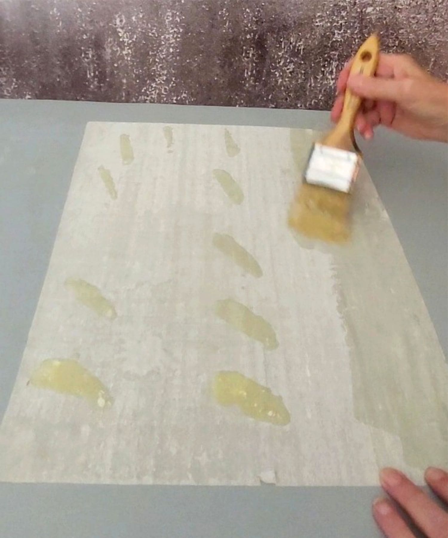 brushing melted butter on layer of phyllo dough