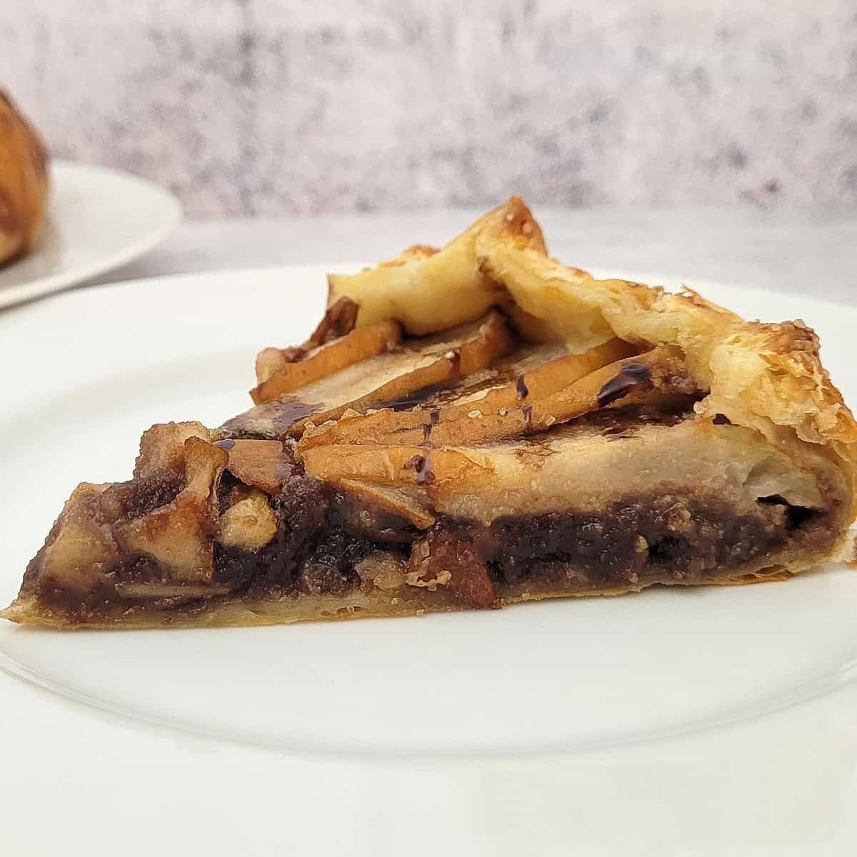 slice of chocolate pear galette with almonds on a plate