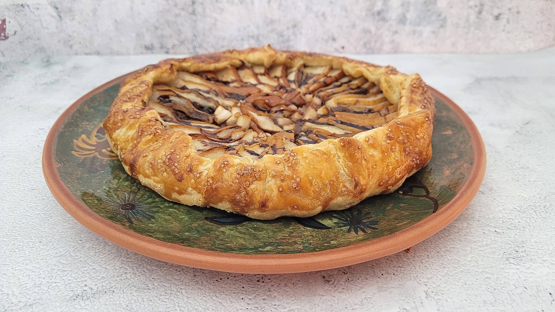 finished chocolate pear galette with almonds on a plate