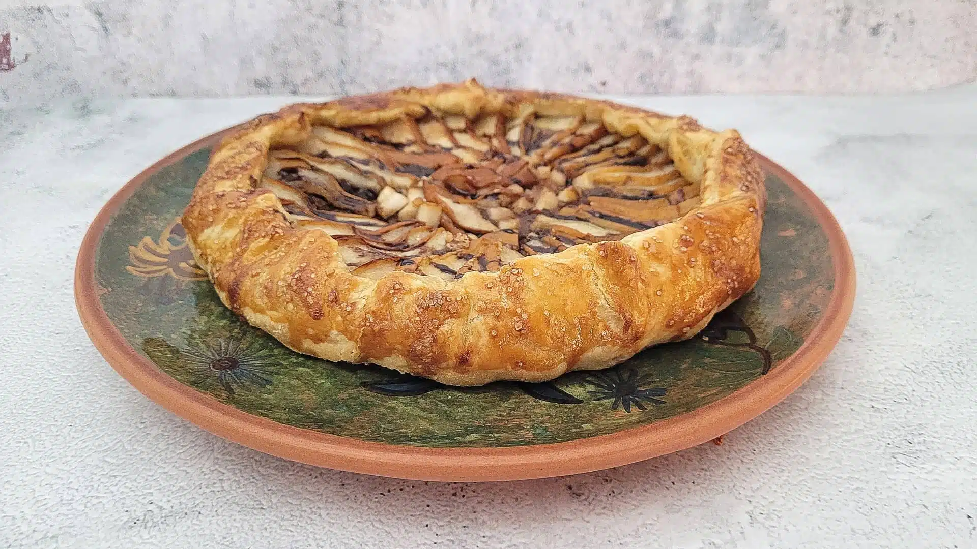 finished chocolate pear galette with almonds on a plate