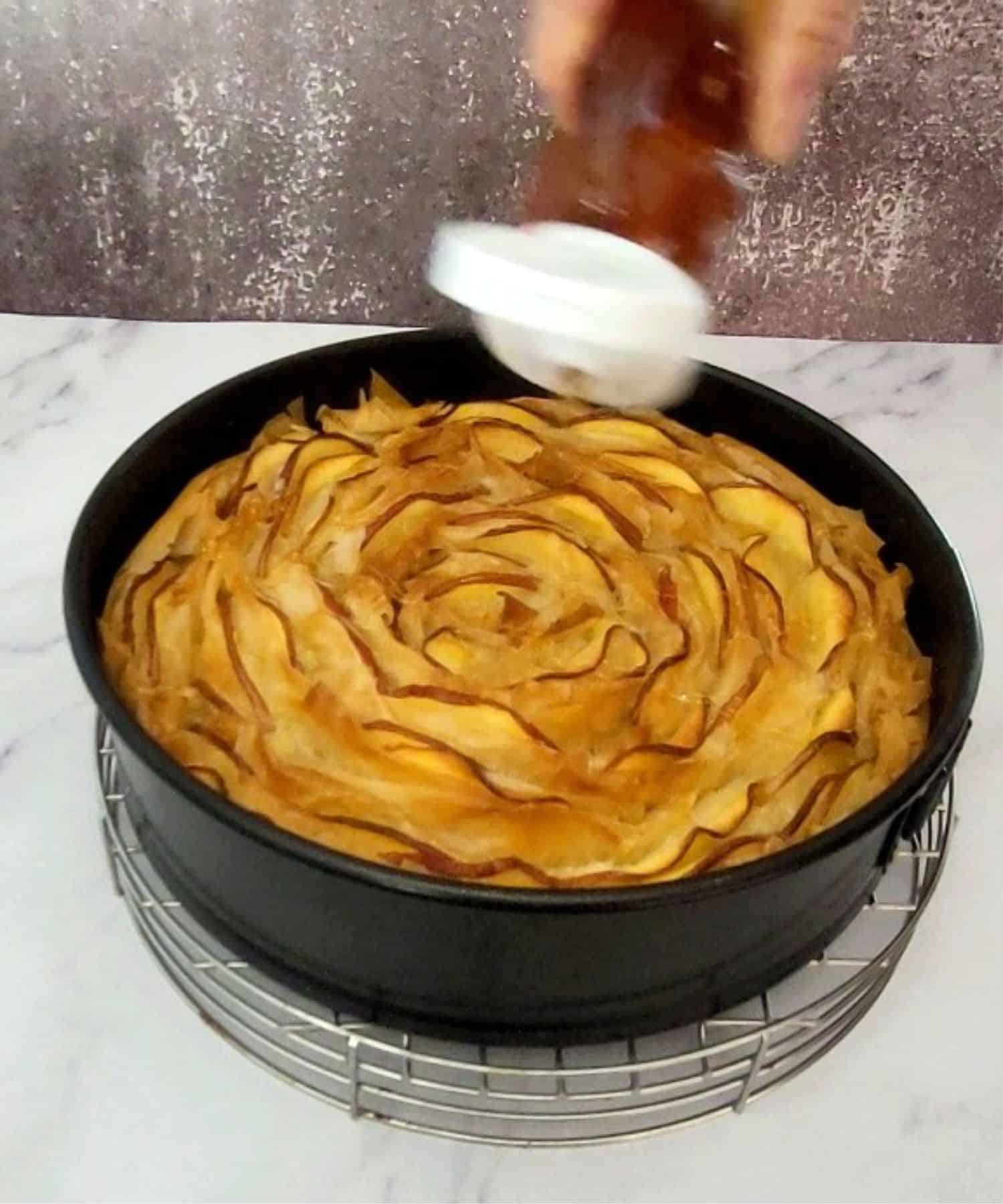 drizzling honey over phyllo crinkle cake after baking