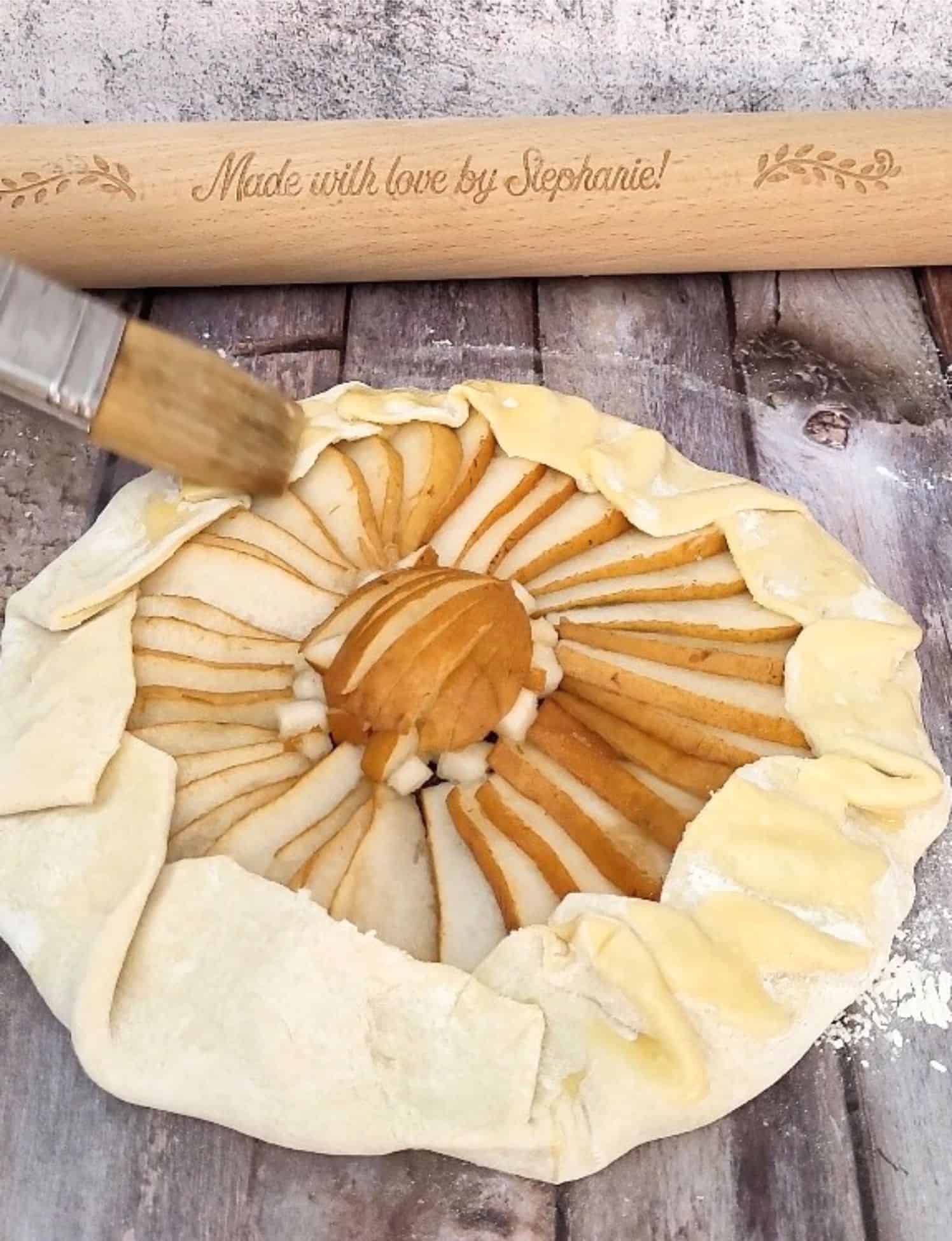 egg wash being applied to puff pastry before baking galette