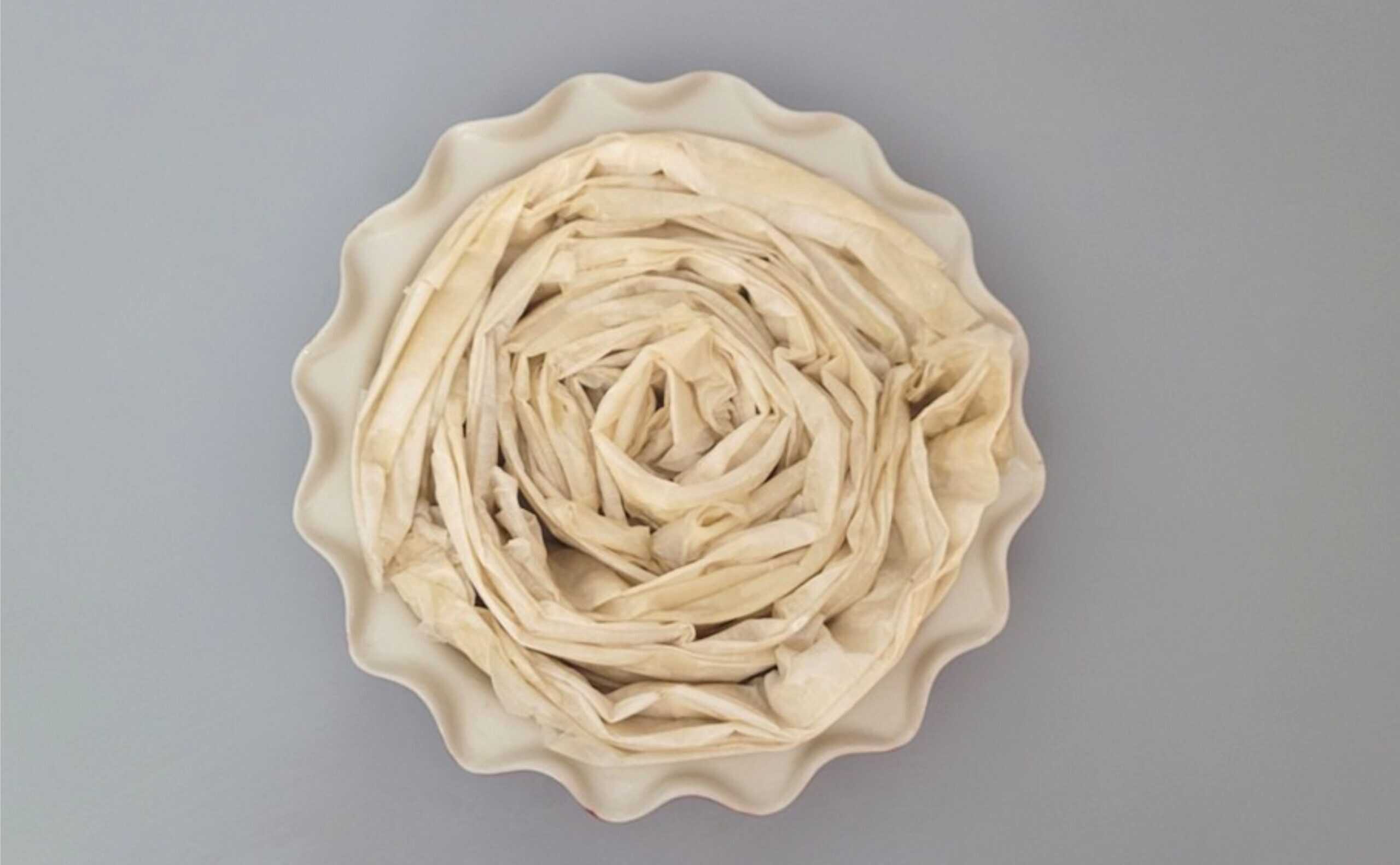 overhead view of pie dish with final layers of dough added