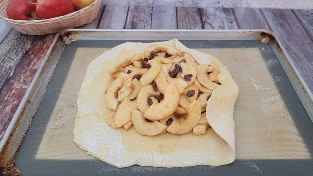 apple and raisin filling piled up in the middle of a sheet of puff pastry