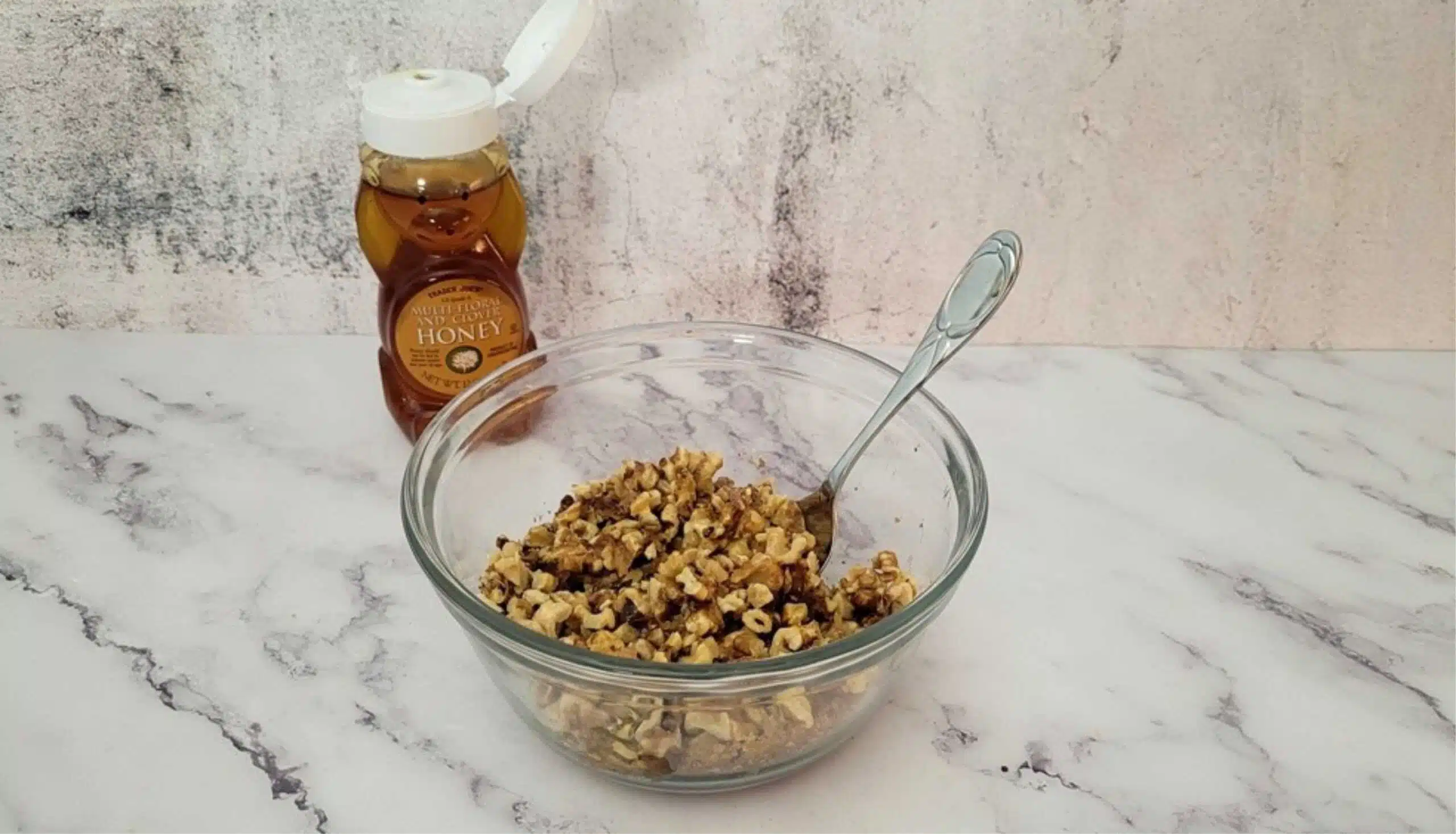 walnut filling mixed together in a bowl and a bottle of honey in background