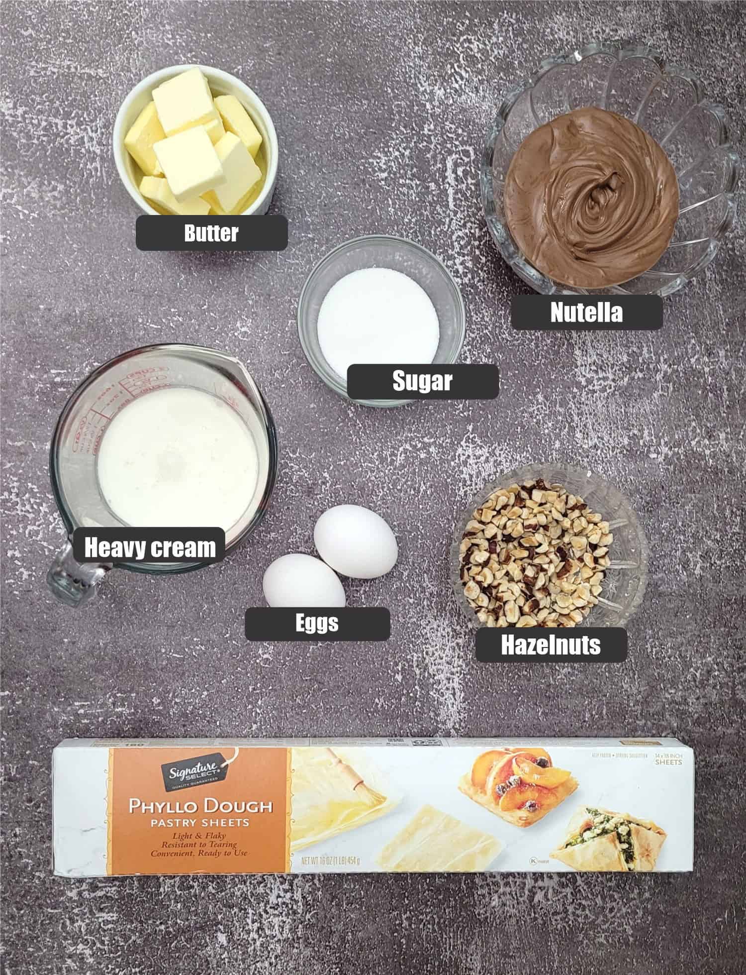 ingredients needed to make Nutella crinkle cake recipe including: phyllo, butter, Nutella, hazelnuts, butter, eggs, sugar and cream