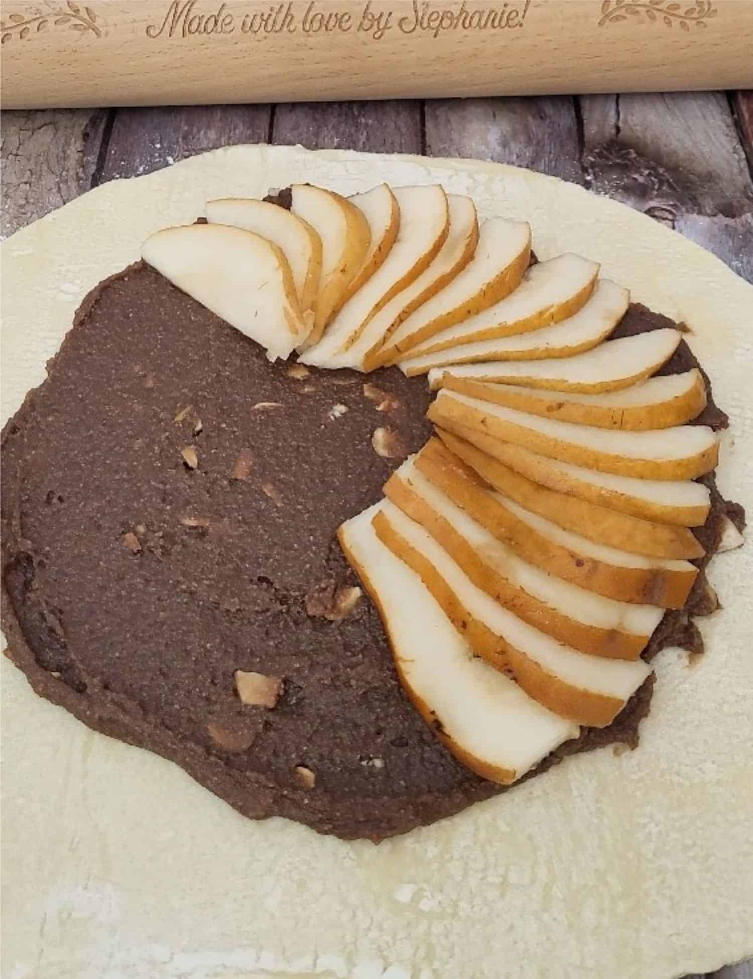 sliced pears being placed over chocolate and almond filling