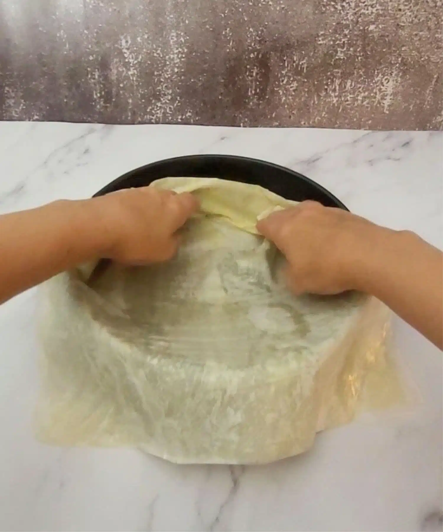 placing first layer of phyllo in cake pan