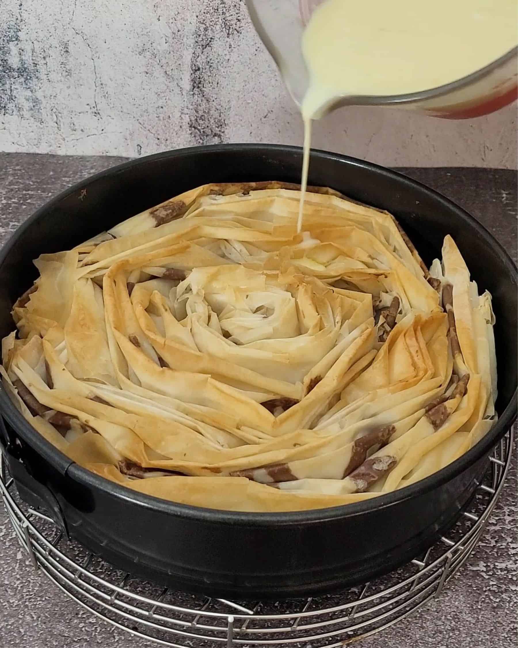 pouring custard sauce over cake before final baking