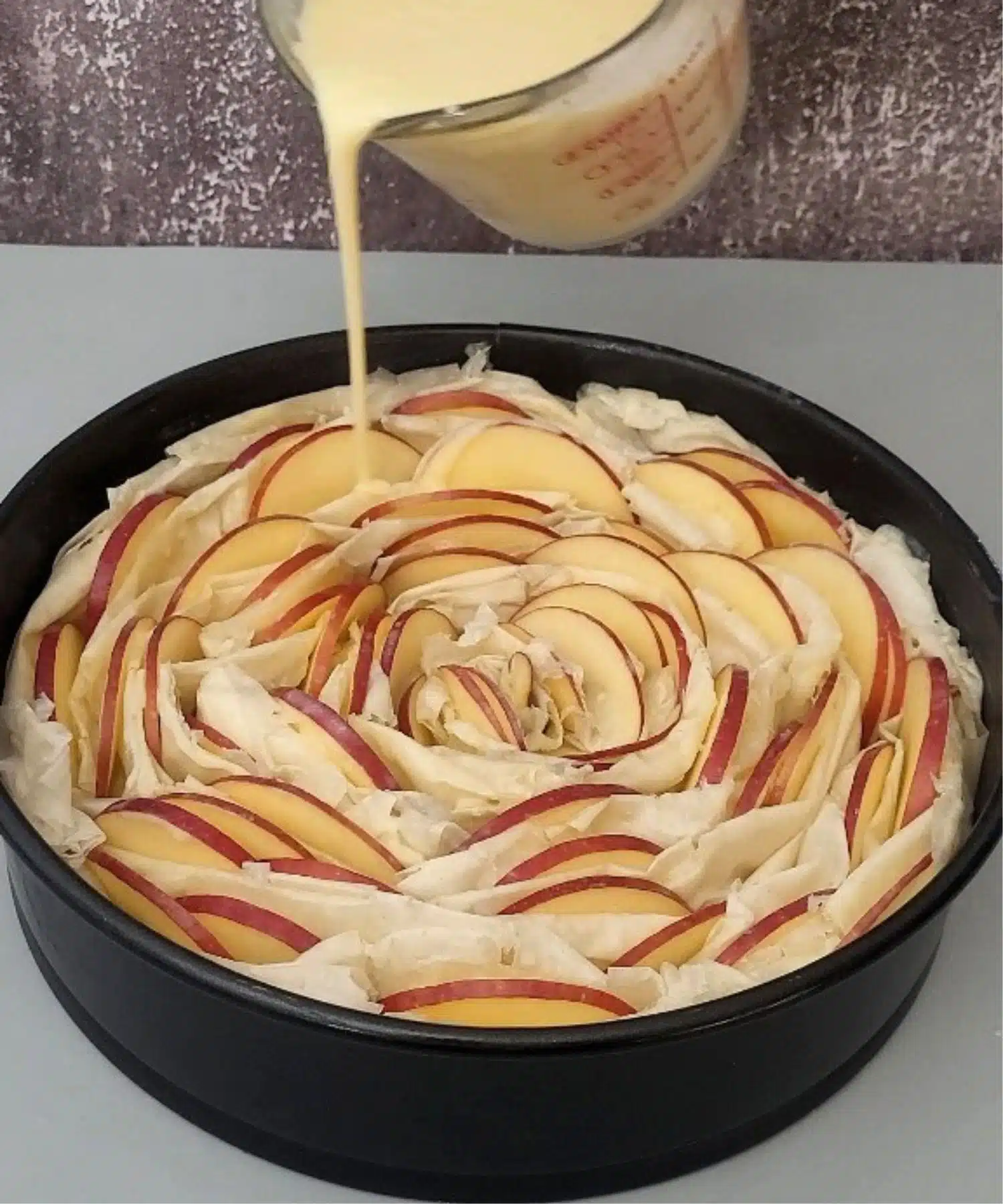 pouring custard sauce over crinkle cake before baking