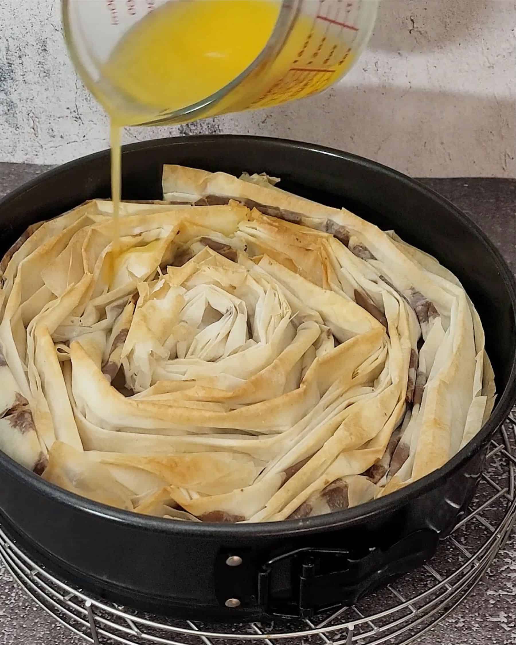 pouring melted butter over Nutella crinkle cake after baking for 10 minutes