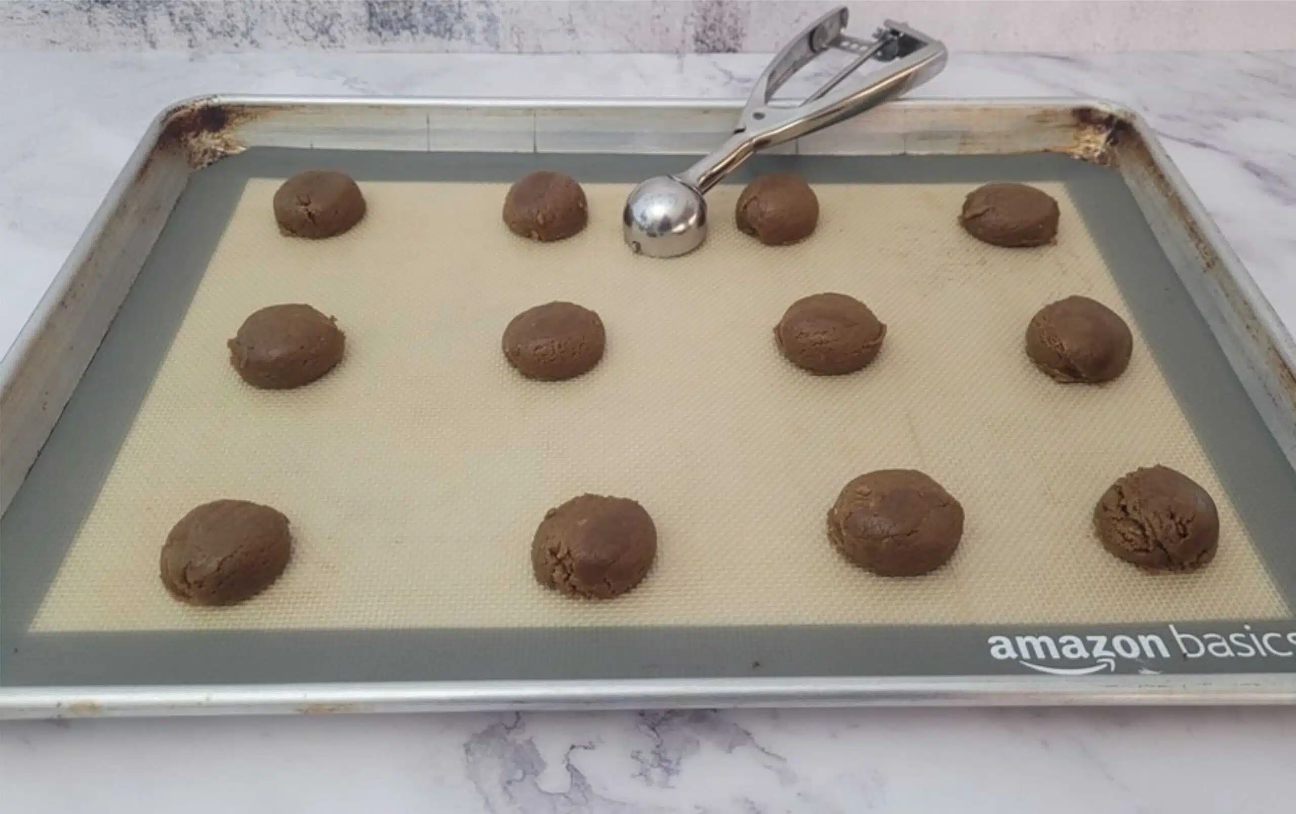 gingerbread whoopie pie cookie dough scooped onto a baking sheet