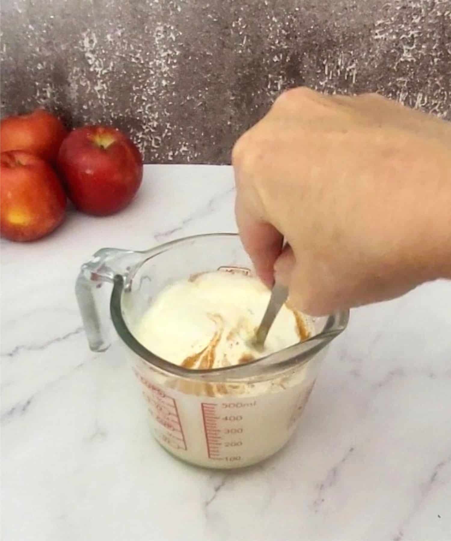 stirring together ingredients to make custard for pouring over cake prior to baking