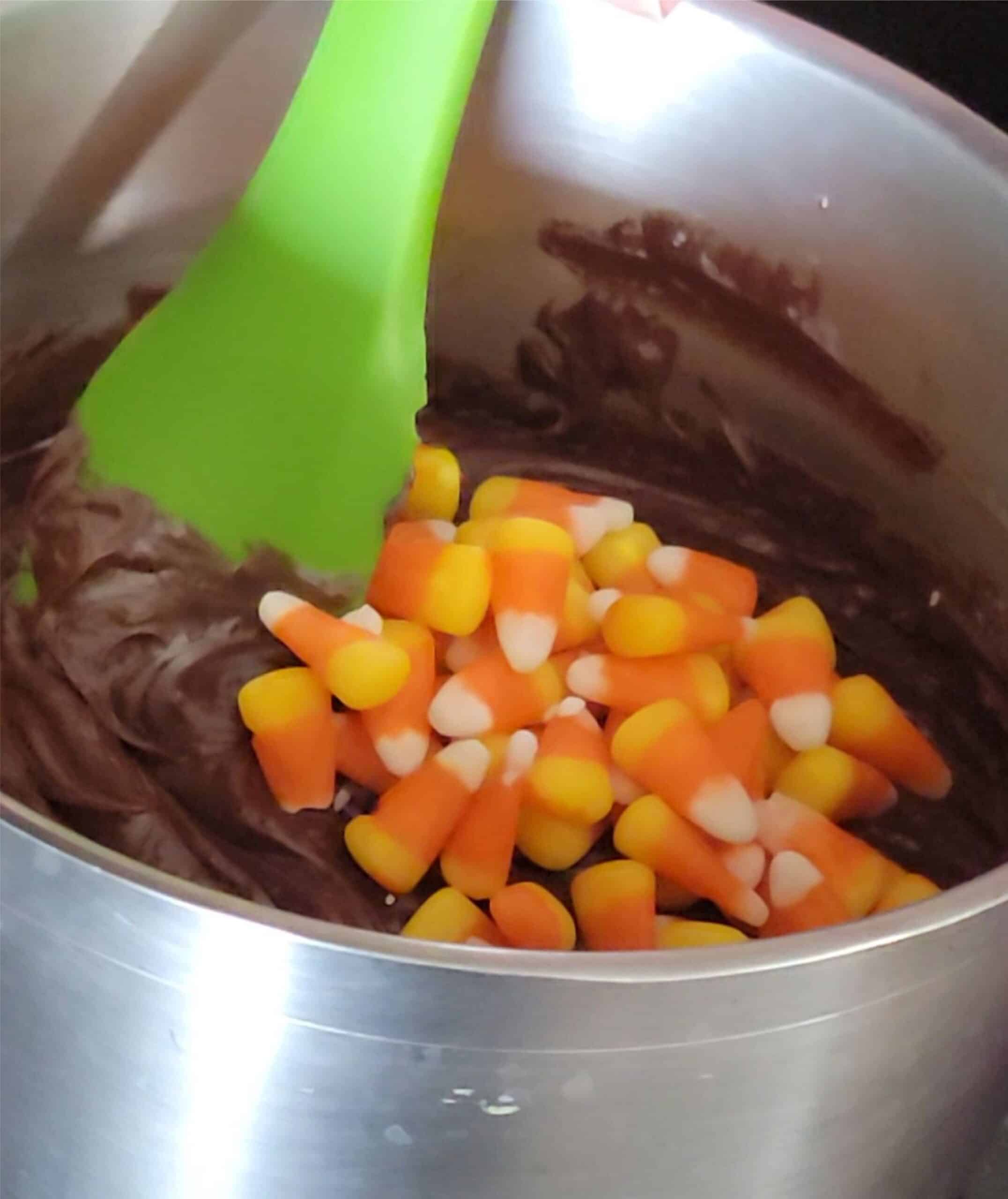 stirring candy corn pieces into chocolate fudge for Halloween