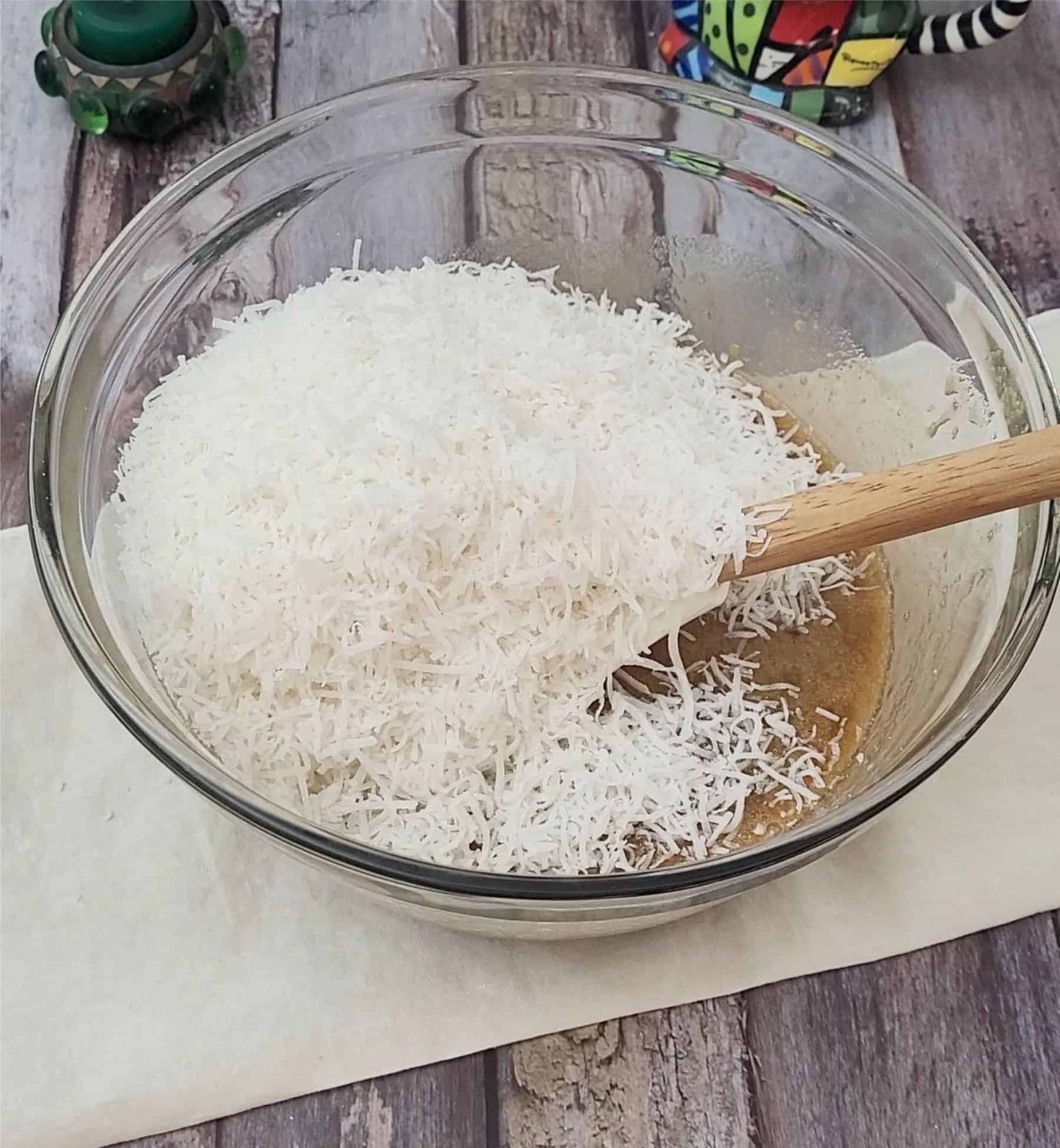 adding coconut and granulated sugar to mixing bowl to make topping for easy coconut cookie bars