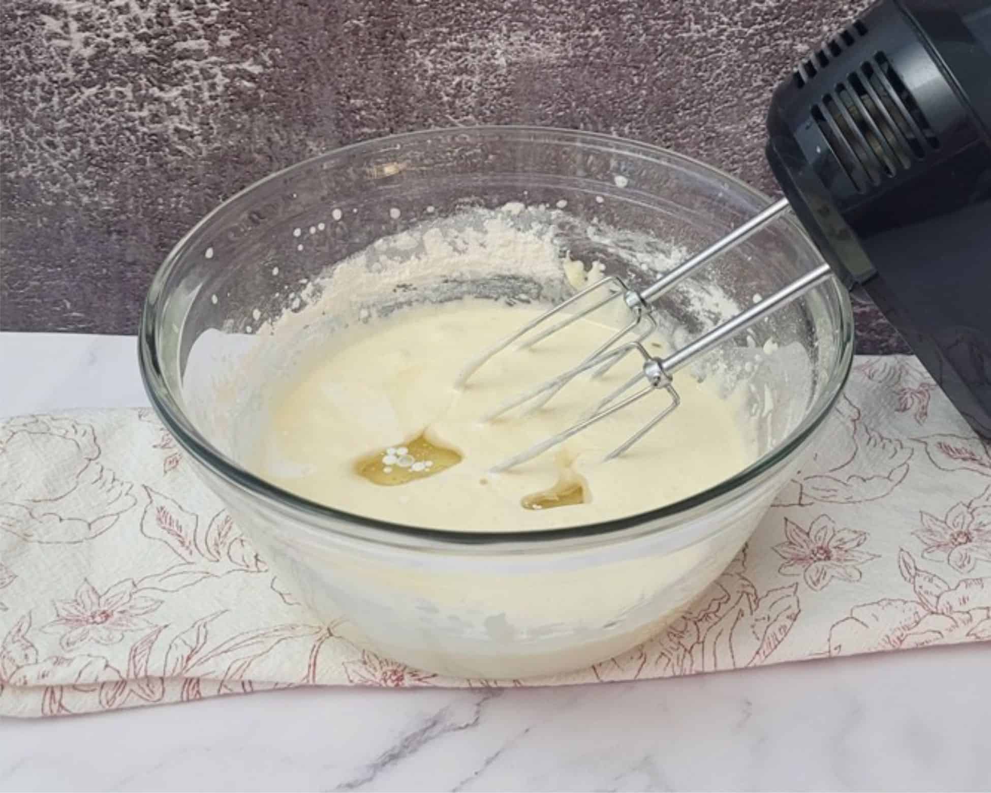 milk and vegetable oil added to cake mixing bowl for a vanilla cake made without butter