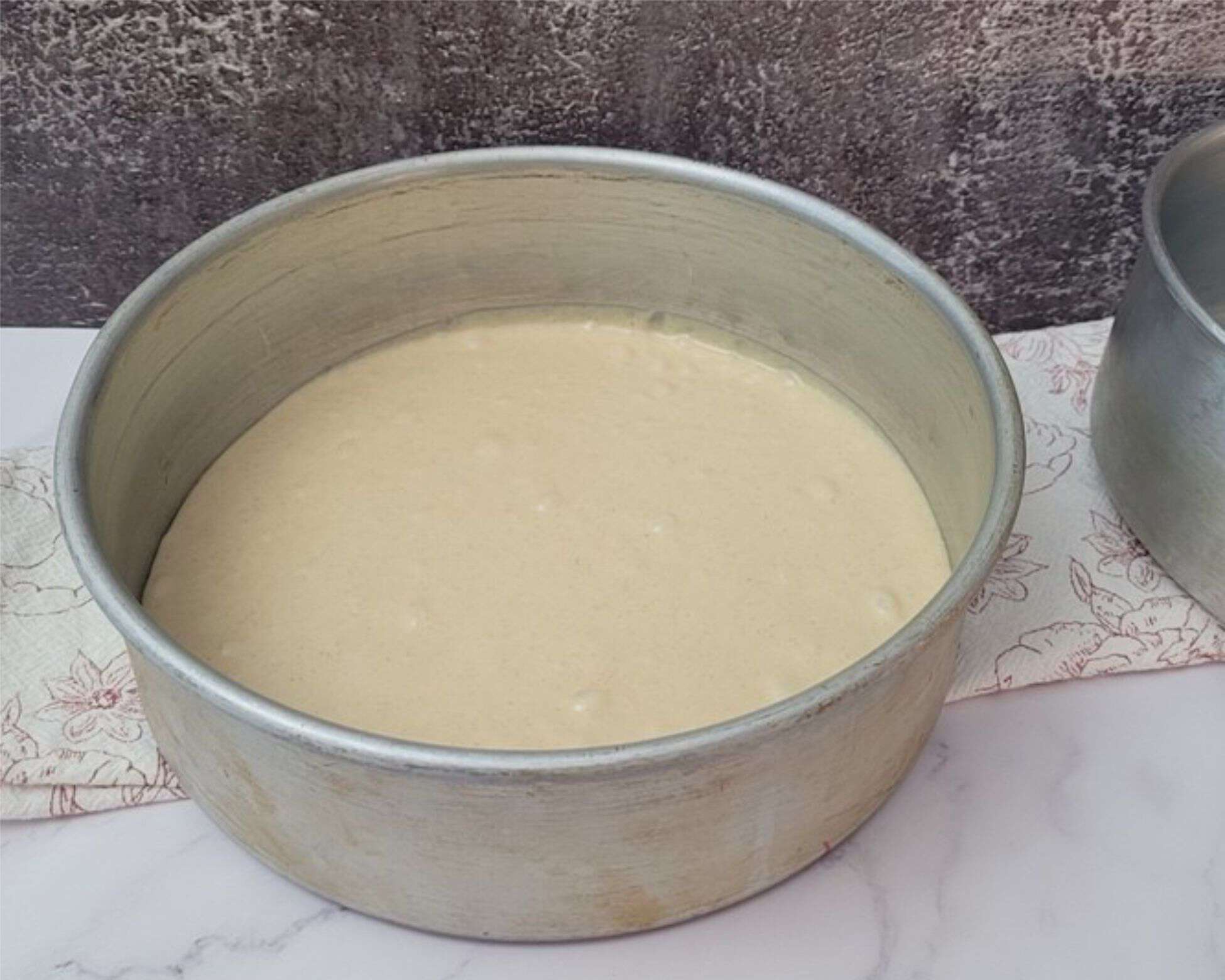 cake batter added to cake pans prior to baking