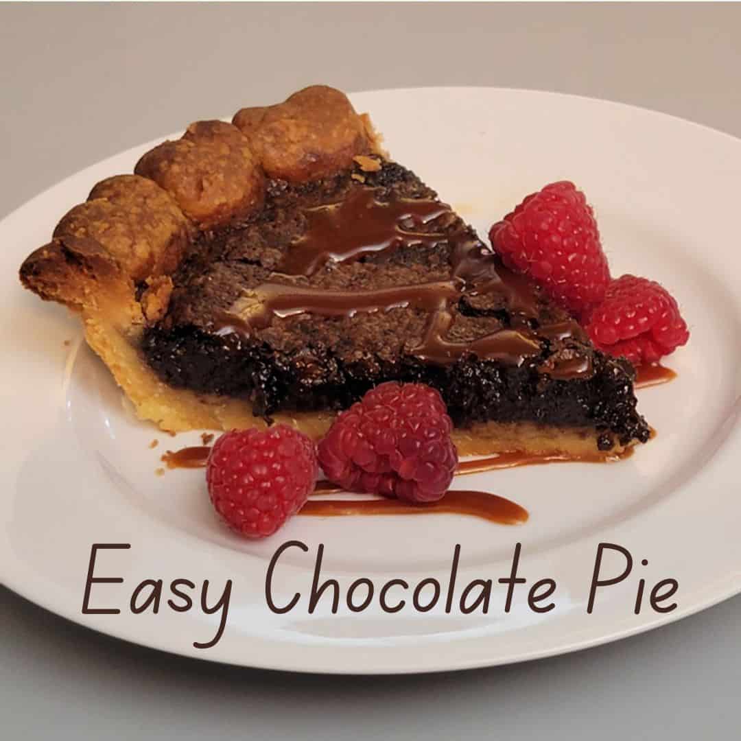 slice of baked chocolate pie on a serving plate and garnished with raspberries