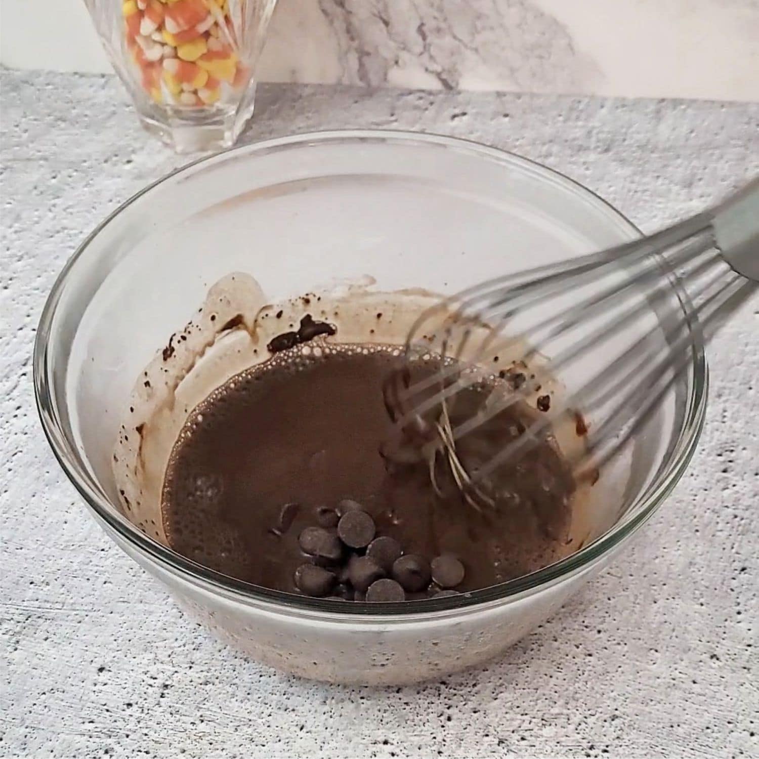 bittersweet chocolate added to brownie batter mixing bowl