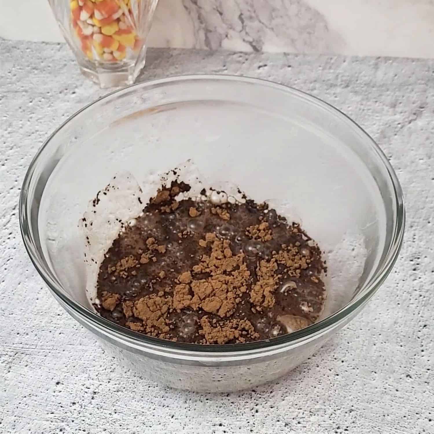 cocoa powder and hot coffee in mixing bowl to start making candy corn brownies using leftover candy corn