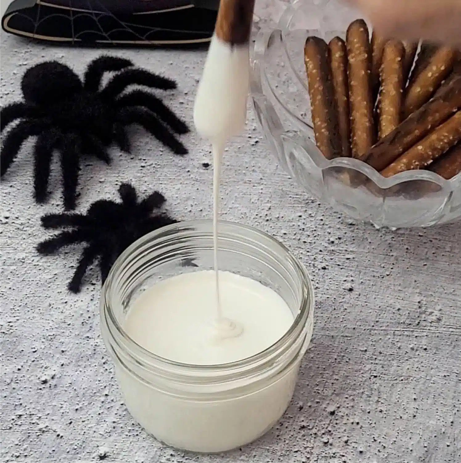 dipping a pretzel in white chocolate