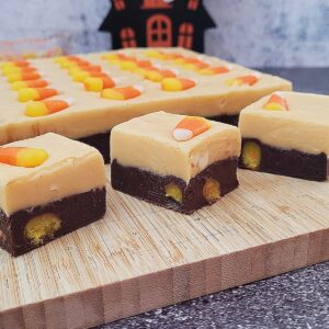 pieces of candy corn fudge on a wooden cutting board