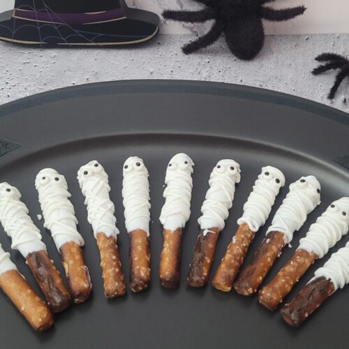 pretzel rods dipped in white candy melts and decorated to look like mummies