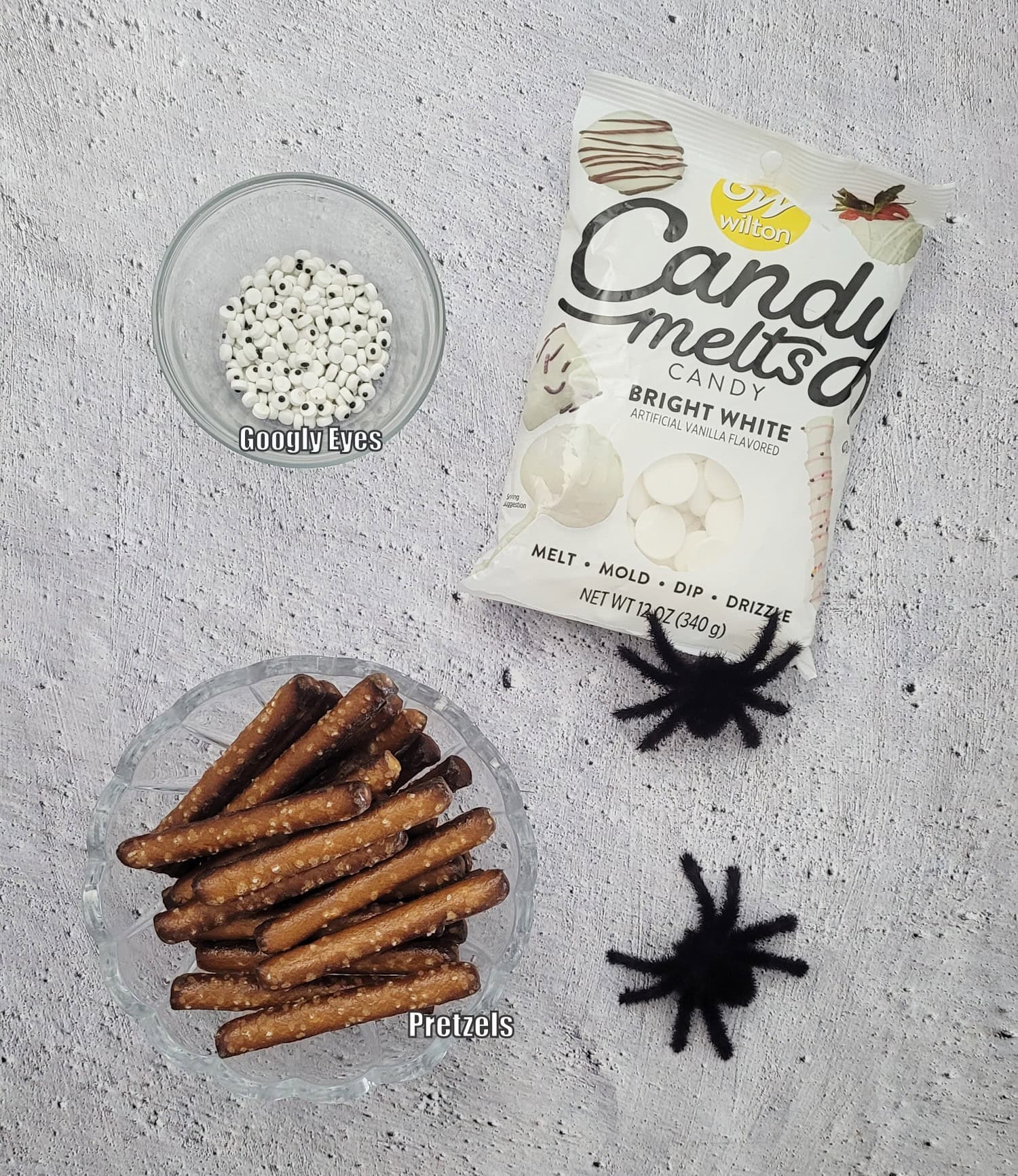 ingredients needed to make recipe including pretzels, white candy wafers and googly candy eyes