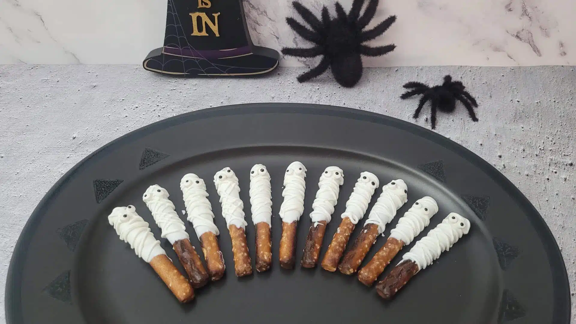 several Halloween mummy pretzel rods on a platter