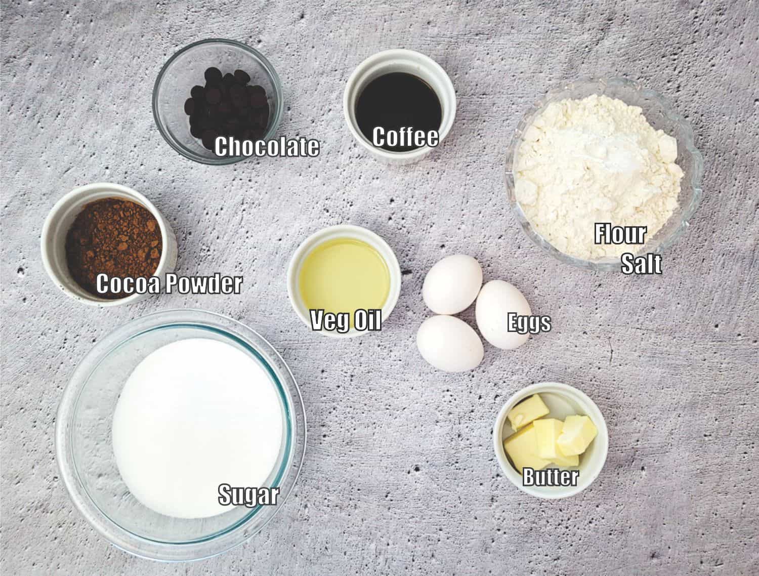 ingredients needed to make brownie batter including chocolate, coffee, cocoa powder, vegetable oil, eggs, flour, salt, sugar and butter