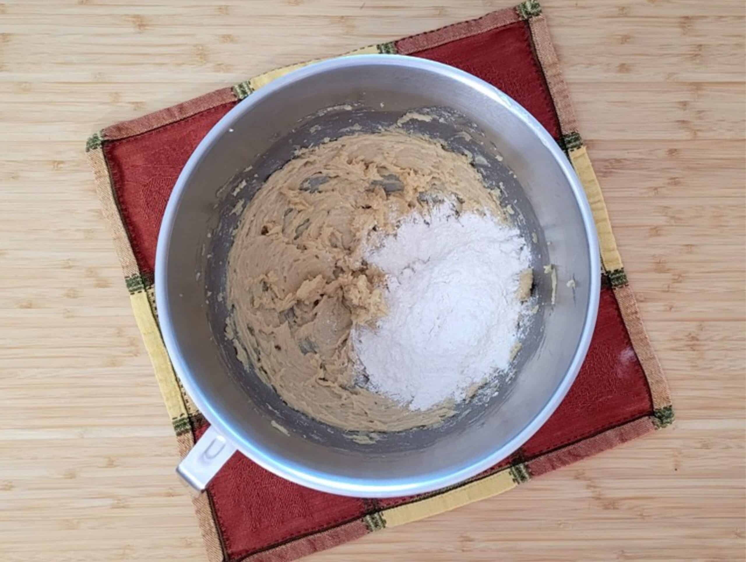 butter, sugar and eggs mixed in a bowl and flour added to make cake batter