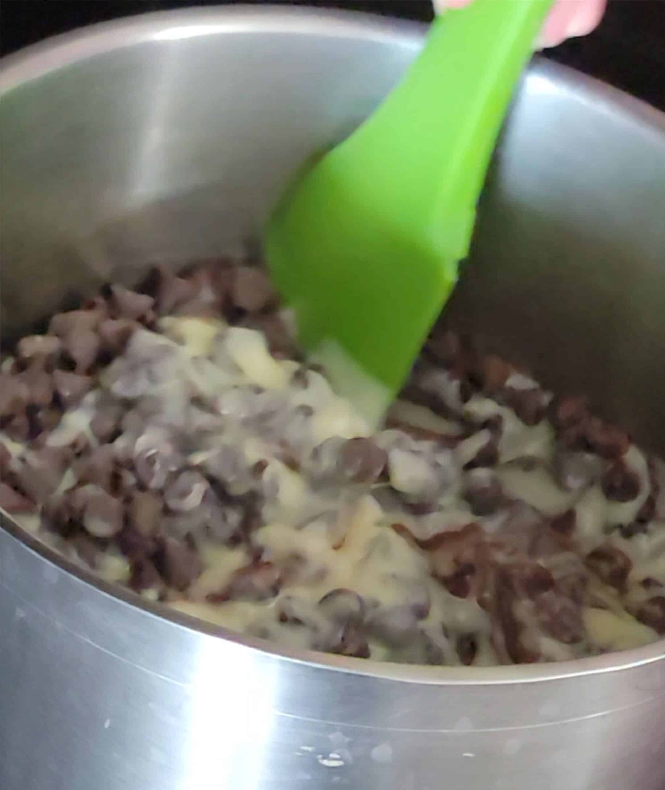 mixing together chocolate chips and sweetened condensed mil in a sauce pan