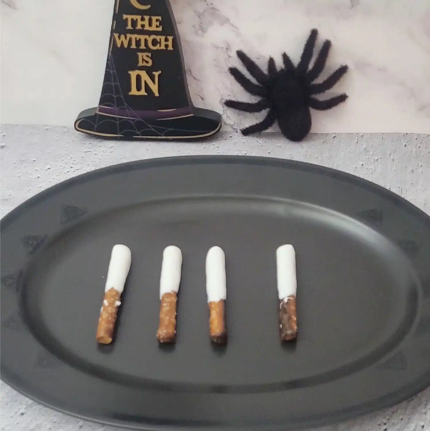 pretzels dipped in white chocolate and placed on a platter to dry