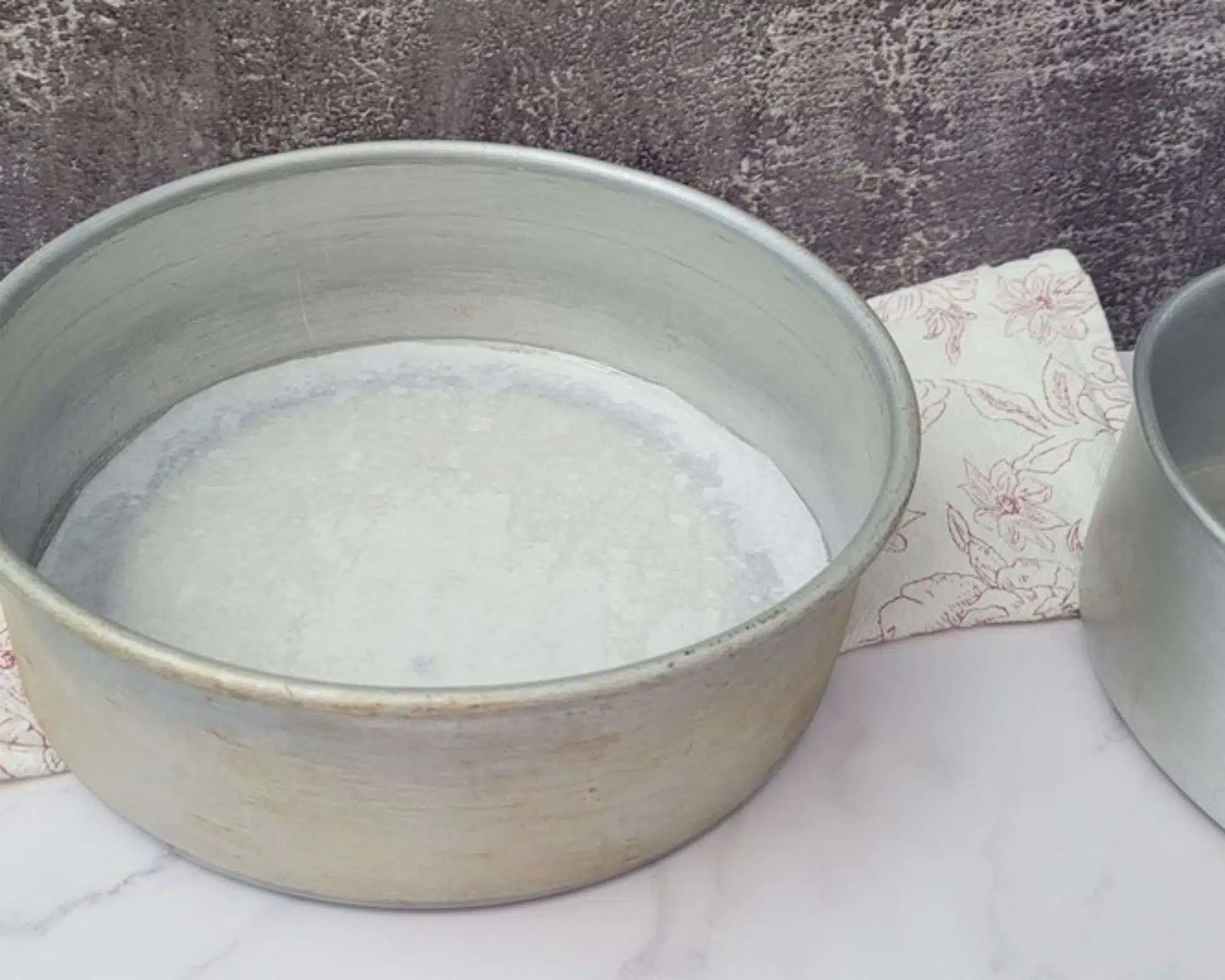 two 8" round cake pans prepared with parchment paper to bake vanilla cake in