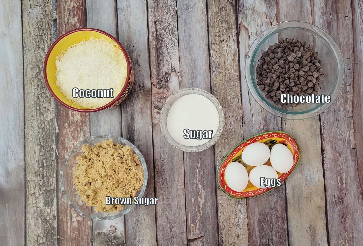 ingredients for topping for chocolate coconut cookie bars including eggs, brown sugar, granulated sugar, chocolate and coconut