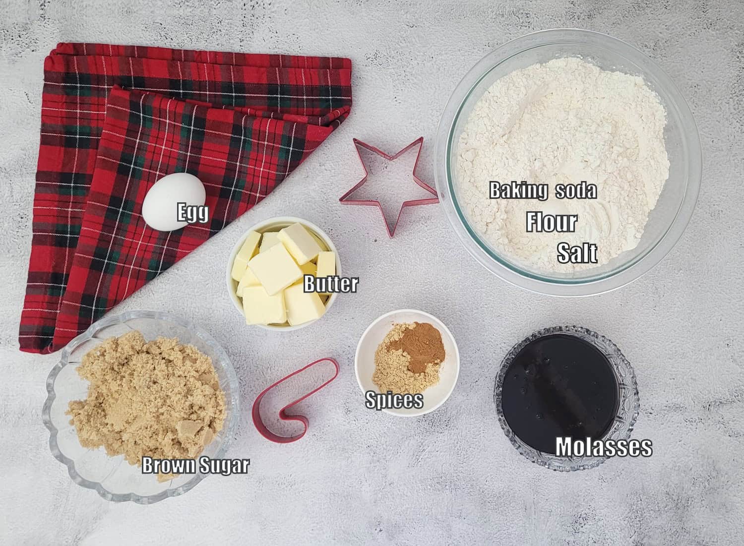 ingredients needed to make gingerbread dough for cookies including flour, salt, baking soda, molasses, spices, butter, egg and brown sugar